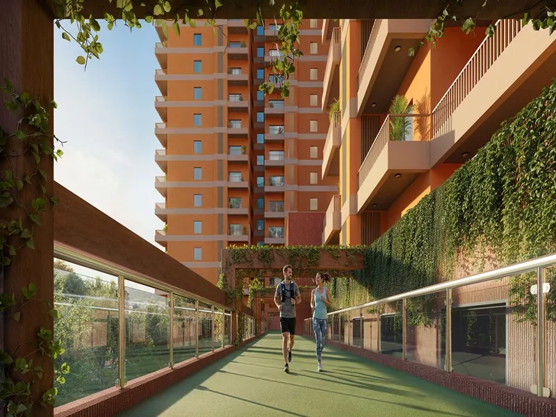 Landscaped walking trail with lush greenery, tall trees, and a paved pathway at Max Estates Sector 59 Gurgaon residential project.