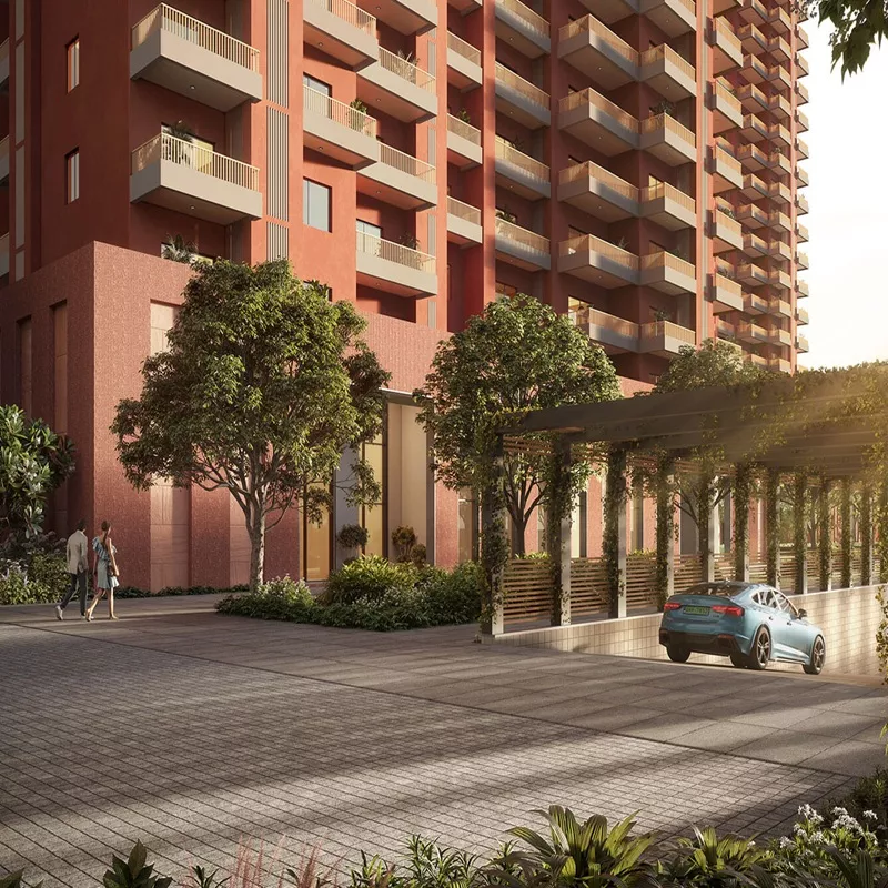 Modern high-rise residential tower with landscaped jogging track, lush greenery, and garden pathway in a premium housing society.